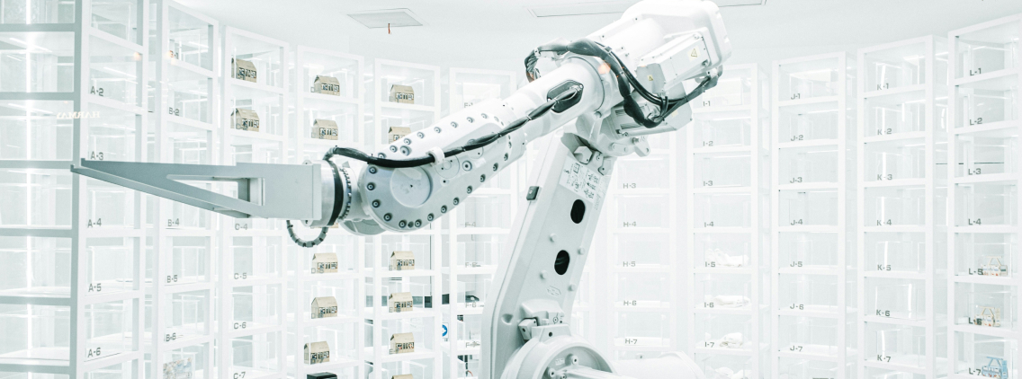 A robotic arm in a sleek, white, high-tech environment surrounded by transparent storage compartments, symbolizing precision, innovation, and advanced automation technology.